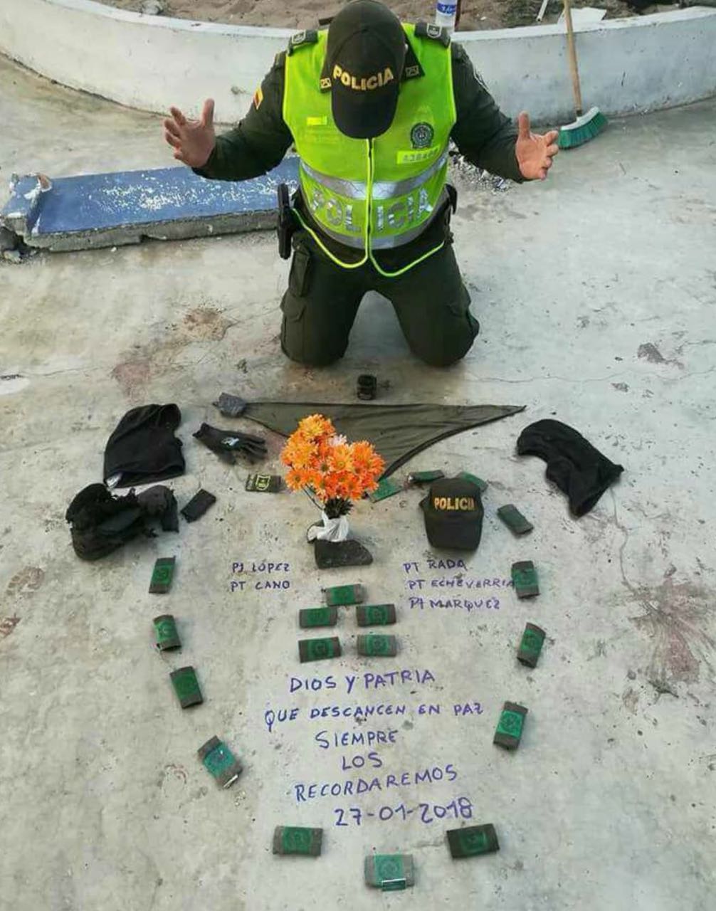 CORTESÍA Un policía reza por sus compañeros fallecidos por el atentado en el barrio San José de Barranquilla.