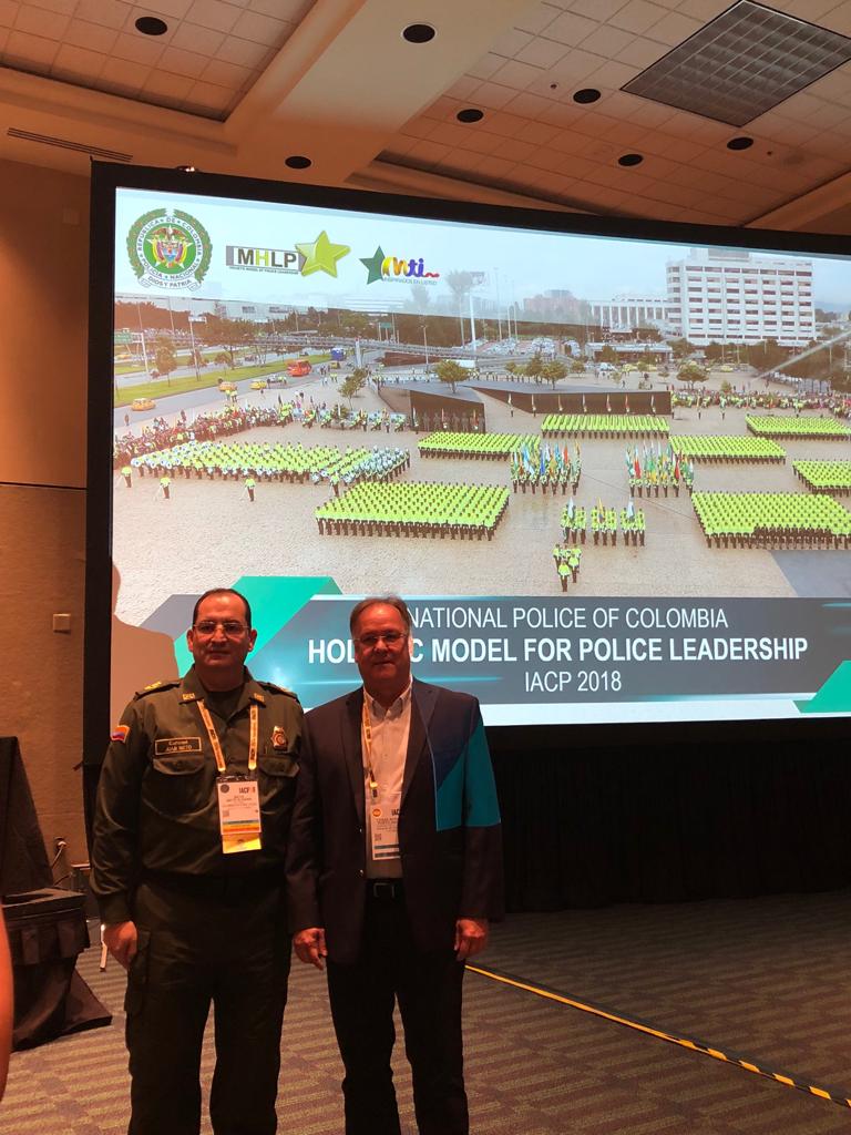 El conferencista con el teniente de la reserva de la Policía de Colombia, César Porto.