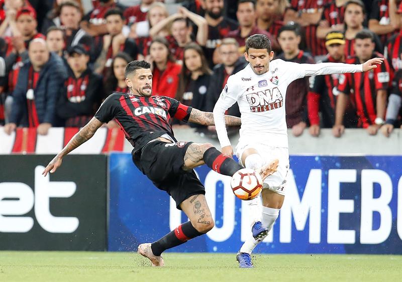 Lucho González de Paranaense enfrentando la marca de Jadson.