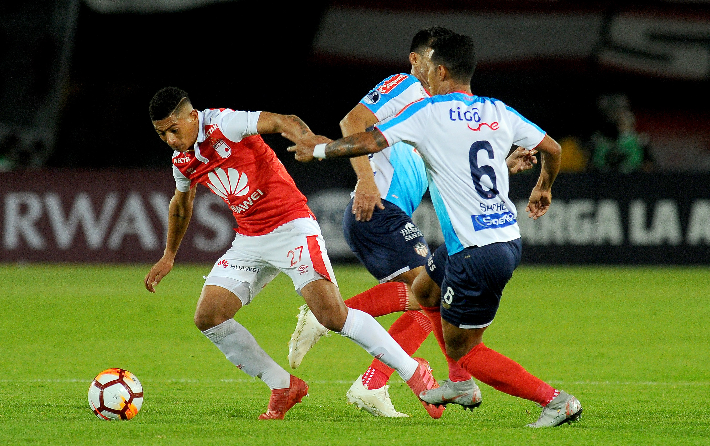 James Sánchez marca a un jugador de Santa Fe. 