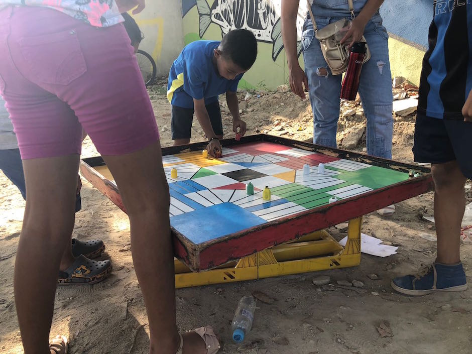 Los niños jugando parqués.