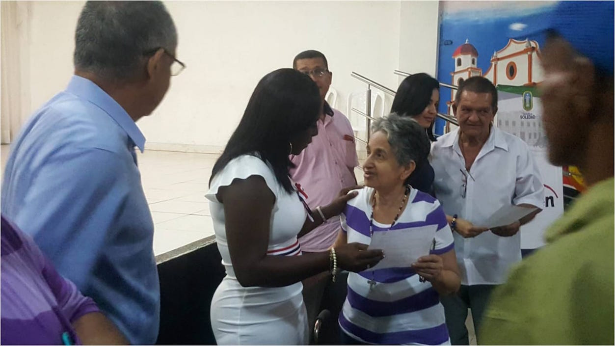 Una de las beneficiarias recibiendo la carta-cheque.