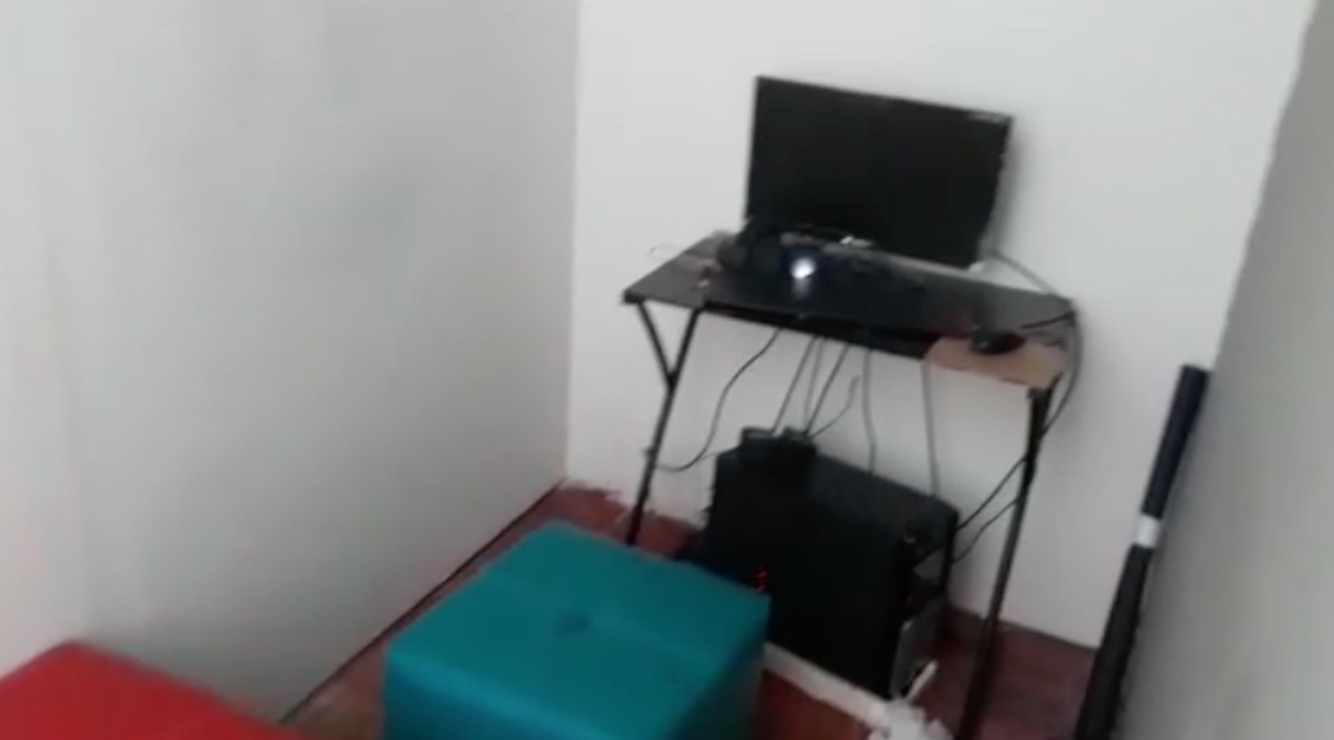 Otro de los cuartos con computador, cámara y un sofá. 