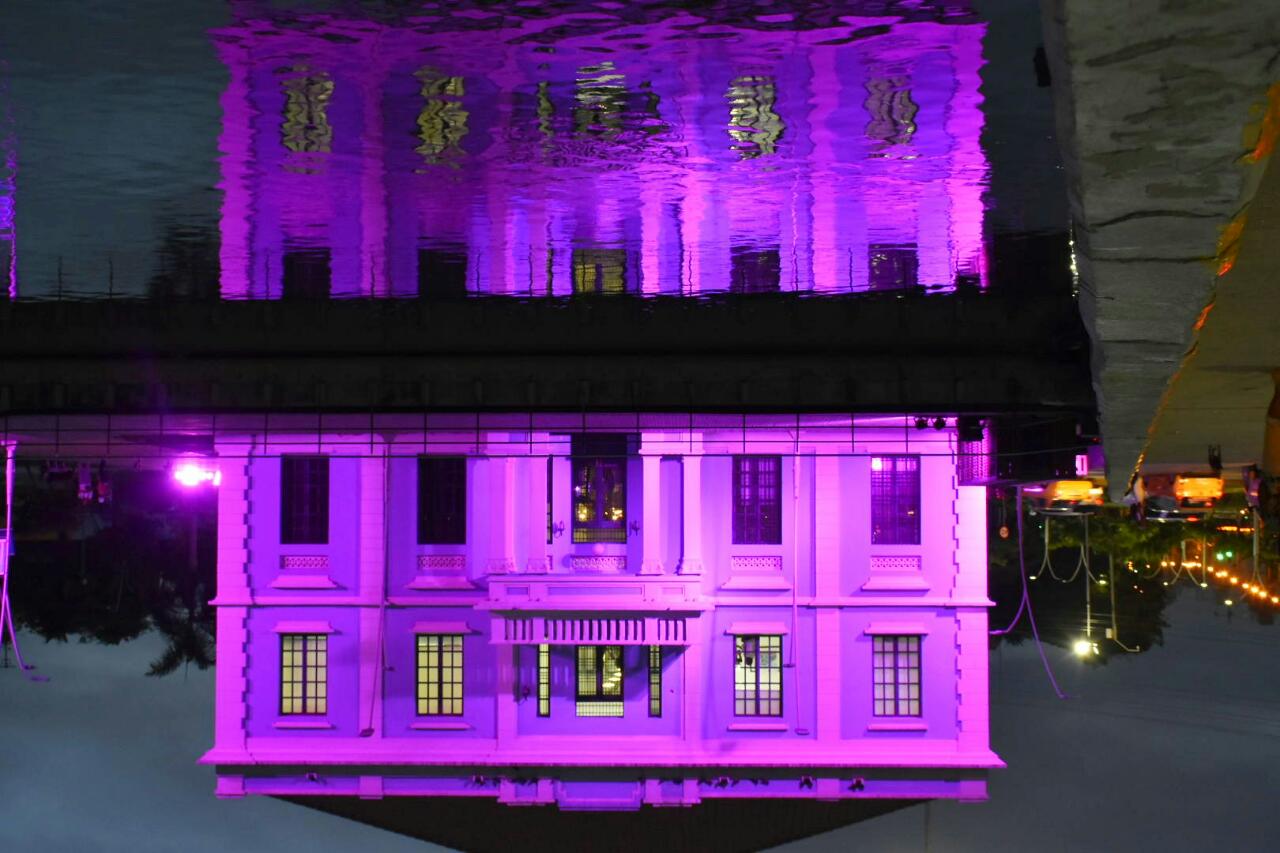 Reflejo de la Intendencia Fluvial iluminada.