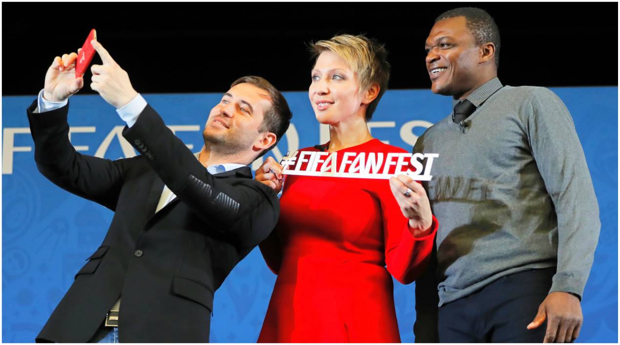 Los exfutbolistas, el ruso Alexander Kerzhakov (i) y el francés Marcel Desailly (d), posan con la periodista rusa Yana Churikova (c) para una foto.