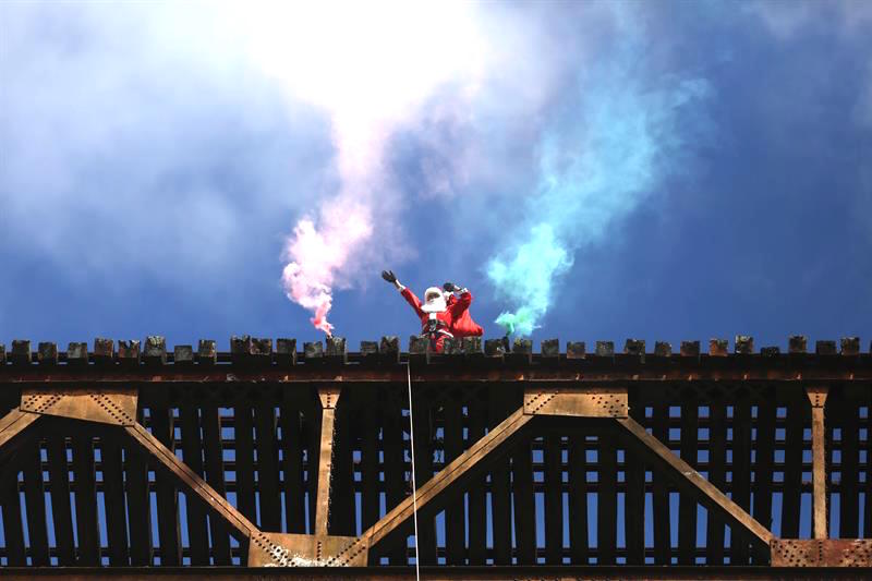 Un bombero desciende sobre el asentamiento de la Buena Esperanza, en Ciudad de Guatemala, para entregar regalos a niños de escasos recursos.