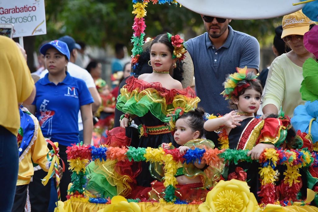 Los niños desfilando en pequeñas carrozas.