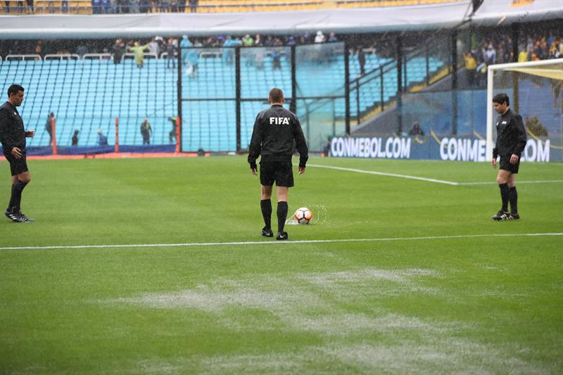 El equipo arbitral inspeccionando la cancha.