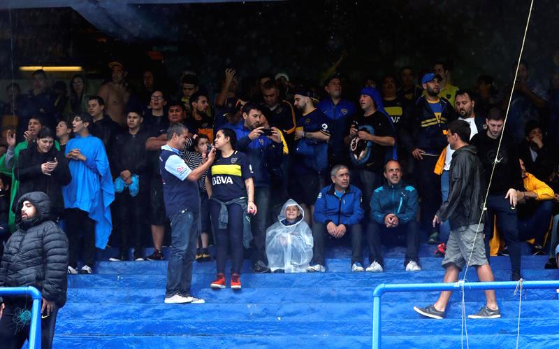 Un grupo de hinchas protegiéndose de la lluvia.