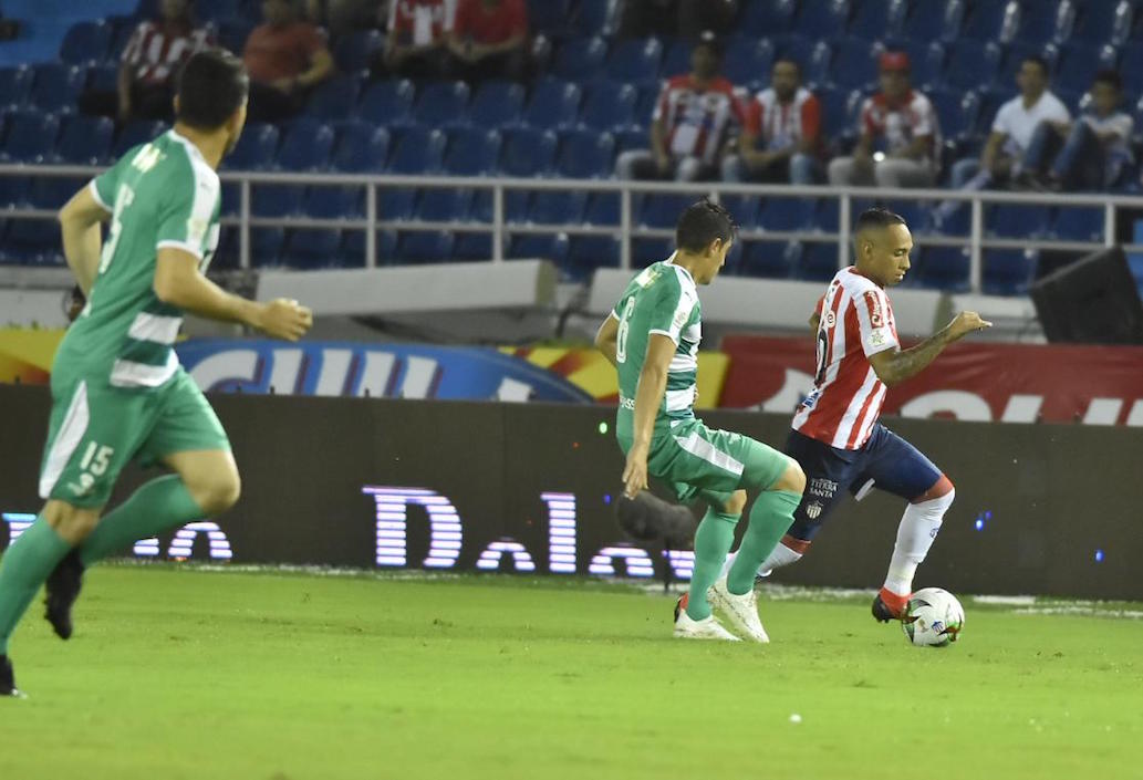 Jarlan Barrera eludiendo la marca de Pablo Lima.