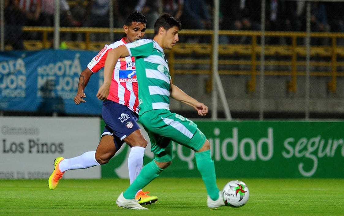 Rafael Pérez luchando el esférico con Pablo Lima.
