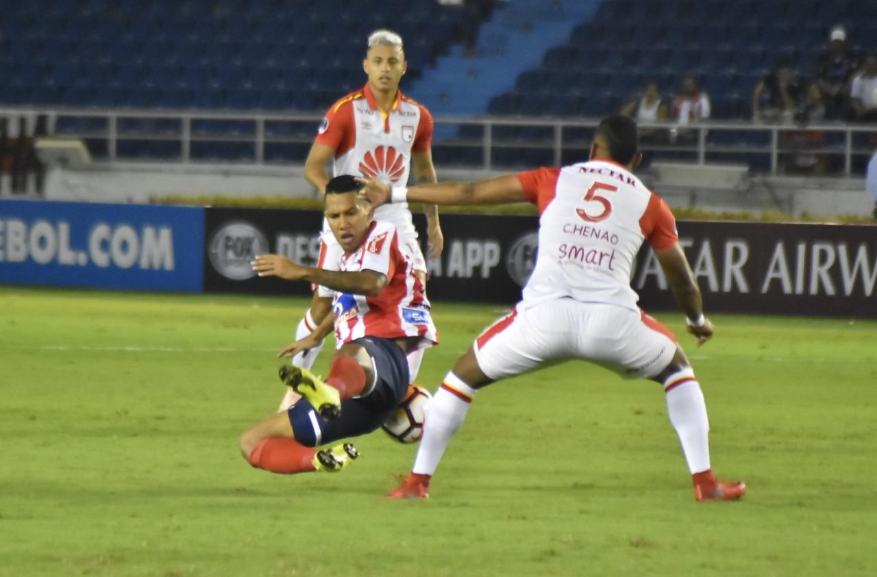James Sánchez disputando el balón con Carlos Henao. 
