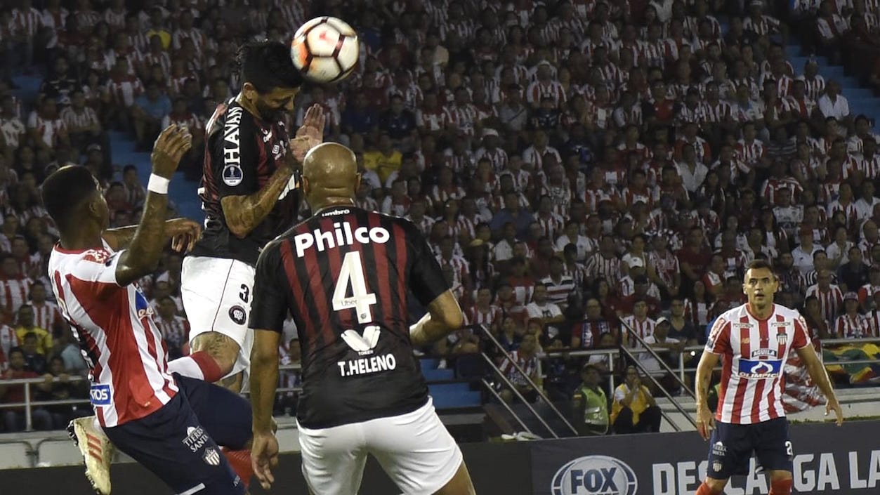 Lucho González cabecea frente a Yony González. Atento Thiago Heleno.