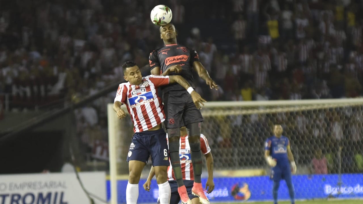 James Sánchez disputando el balón con Juan Fernando Caicedo.
