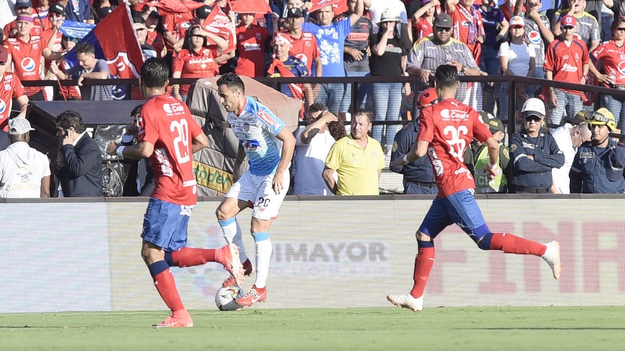 Marlon Piedrahita despejando el balón frente a la marca de Sebastián Macías.