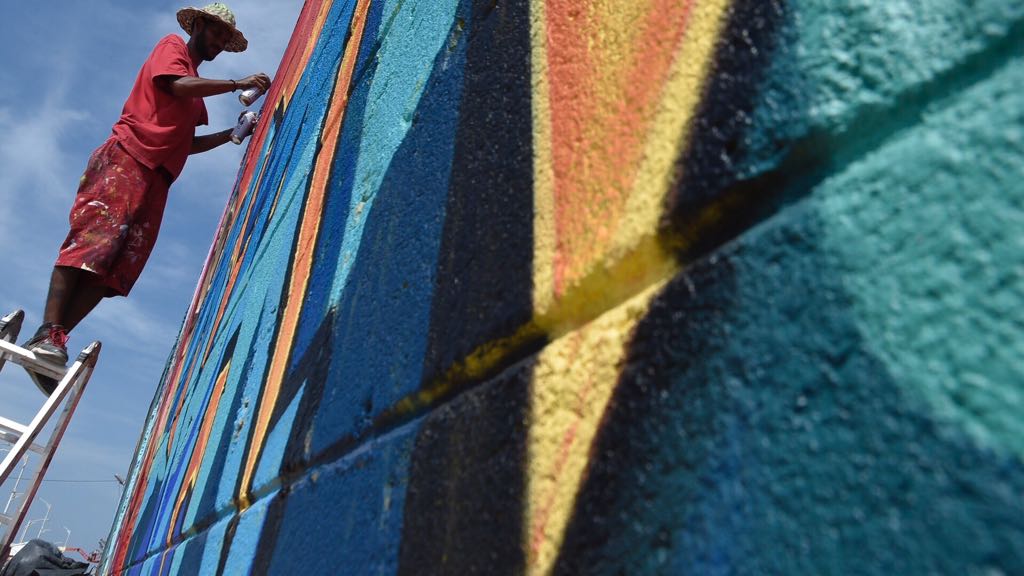 Rafael Matos en el mural que levanta en el Malecón del Río.