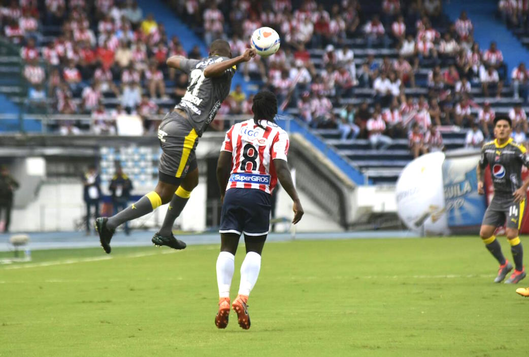 Elvis Mosquera despejando el balón ante el asedio de Yimmi Chará.