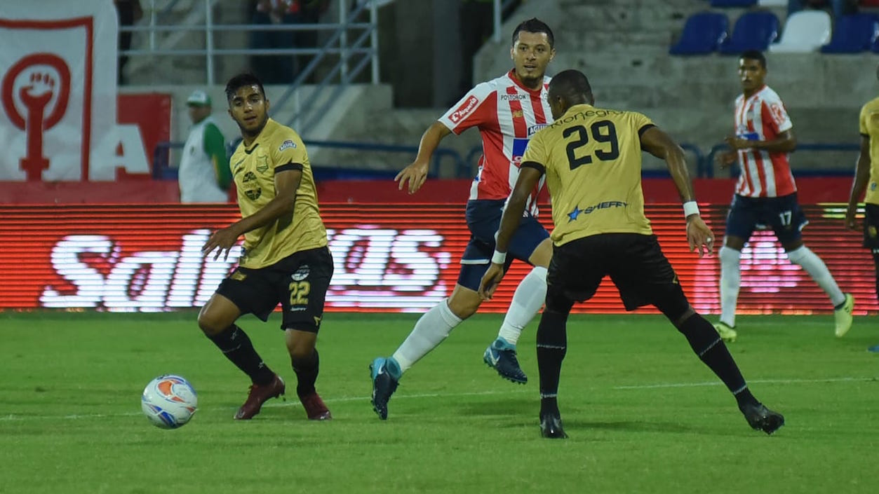 Leonardo Pico filtra un balón entre Leandro Vásquez y Carlos Ramírez.