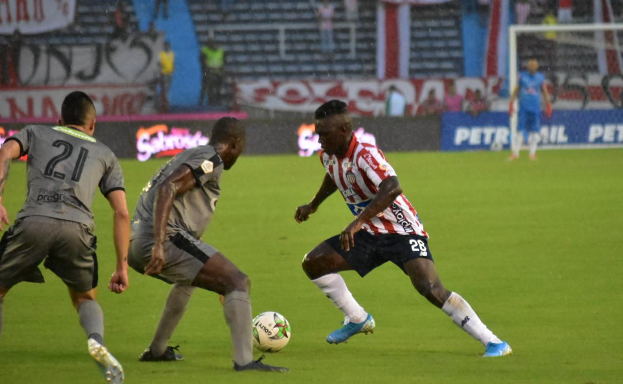 Edwuin Cetré intentando eludir a dos rivales.
