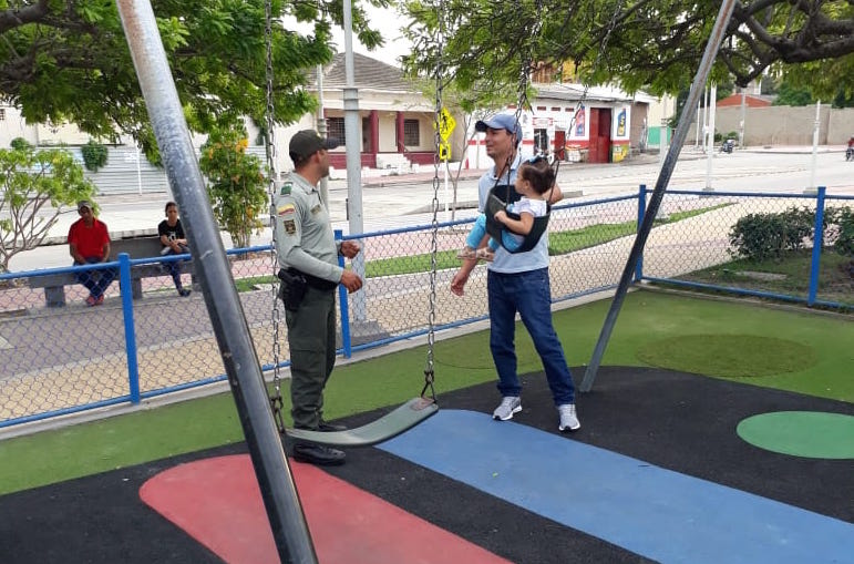 Policía de turismo dialoga con un padre de familia sobre la campaña de prevención de explotación sexual. 