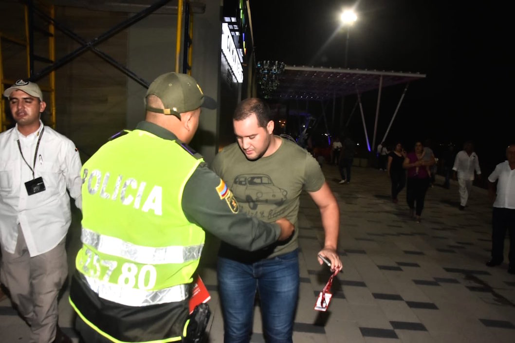 Policía y seguridad presidencial bloqueando al periodista.