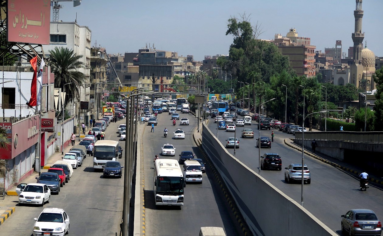 Varios vehículos transitan por una avenida de El Cairo.