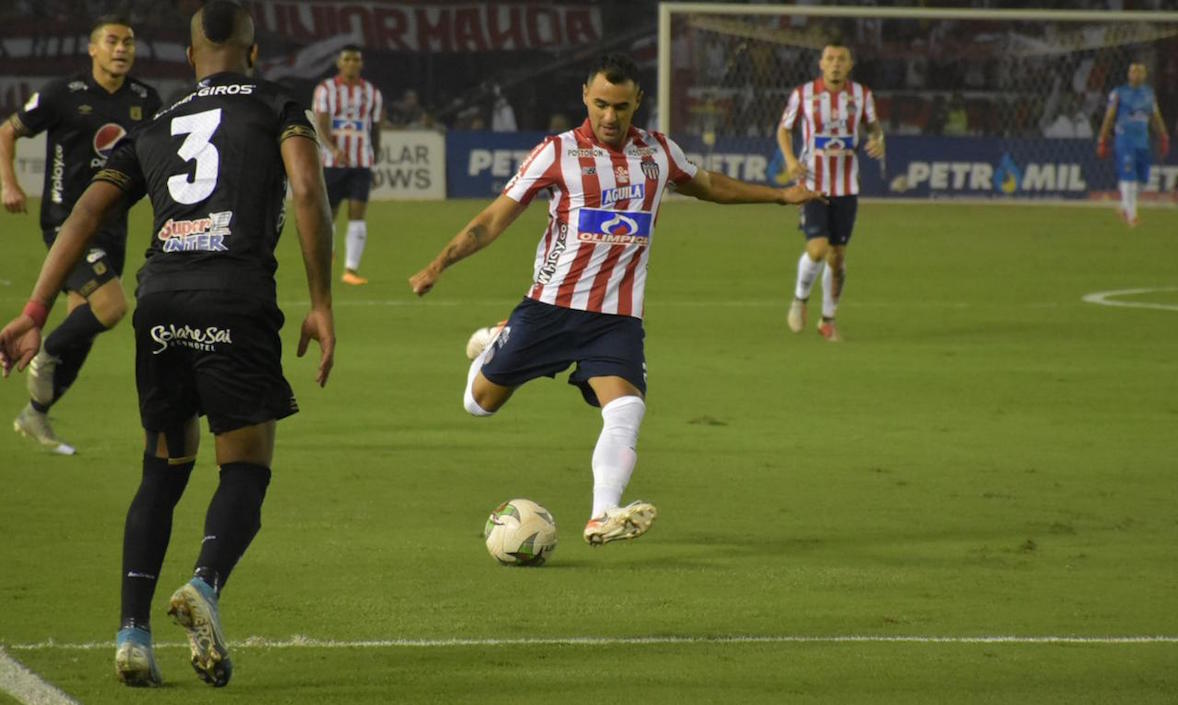 Marlon Piedrahita intenta filtrar un pase ante la marca de Edwin Velasco.