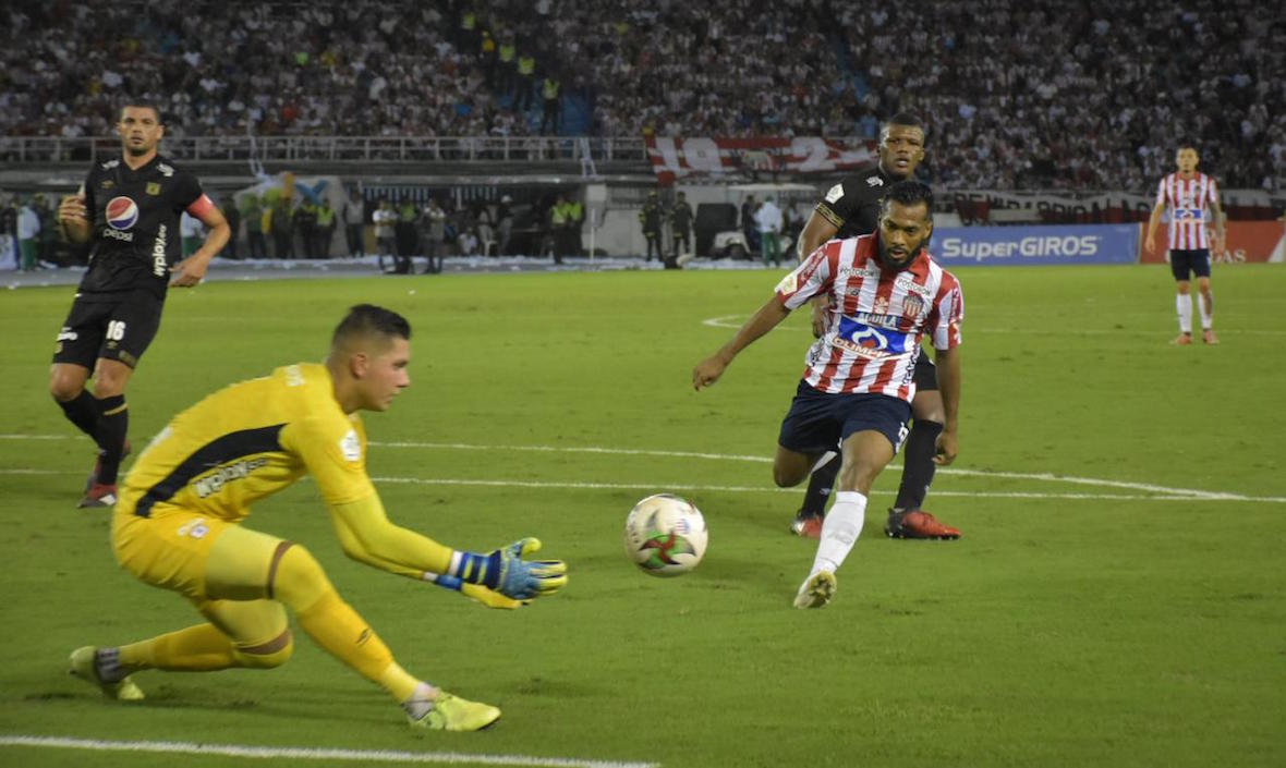 El arquero Neto Volpi controla el balón frente a Luis 'Cariaco' González.