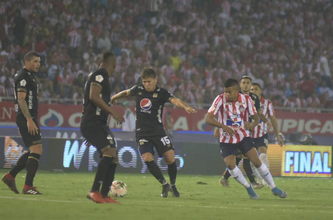 Rafael Carrascal despejando una jugada ante la llegada de Luis Sandoval.
