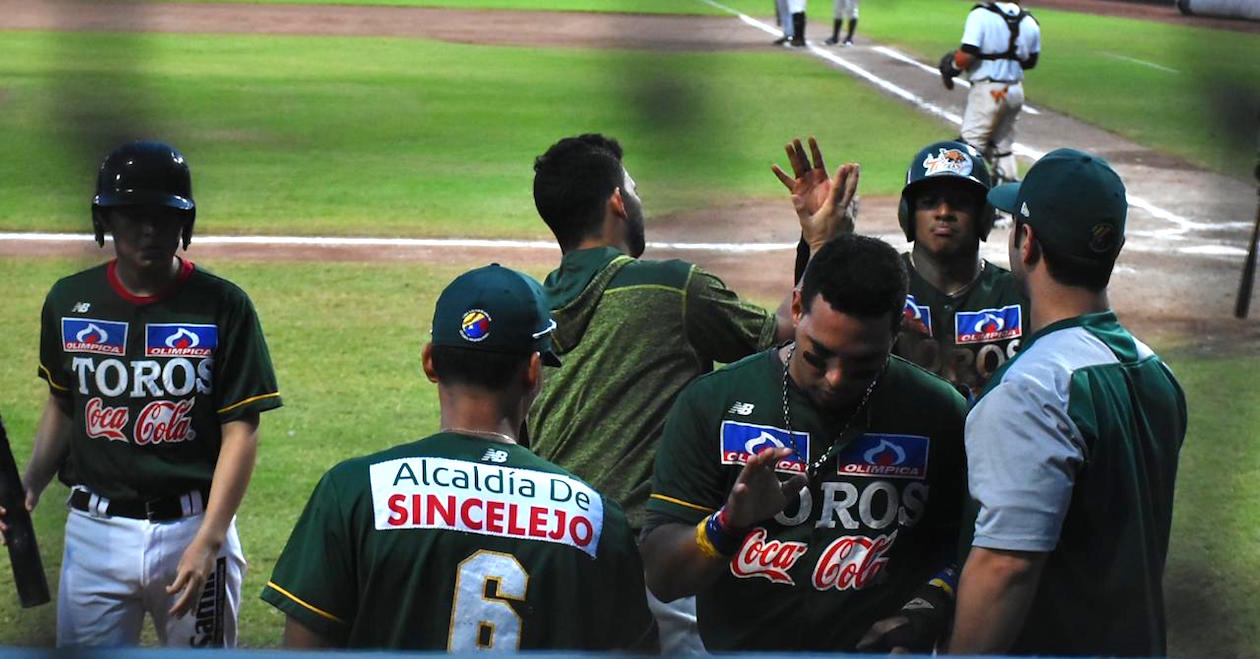 Jugadores de Toros celebran una de las carreras de la victoria.