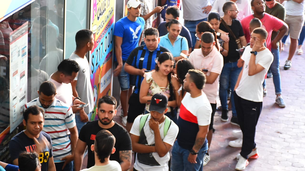 Gente haciendo fila a las afueras de TuBoleta. 