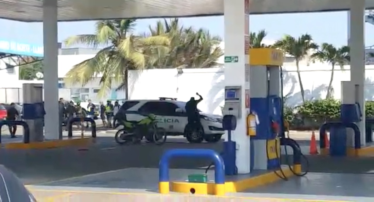 Un encapuchado destruyendo el vidrio panorámico de un vehículo de la Policía.