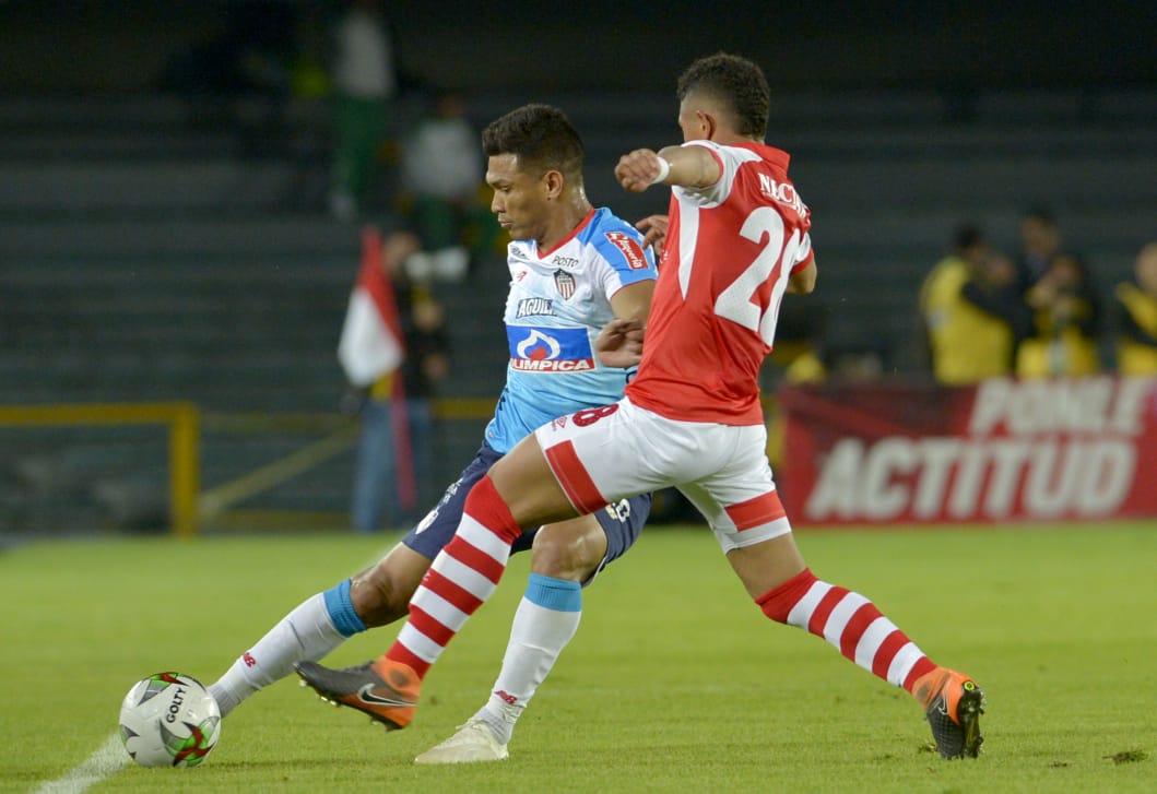 Caros Henao intentando recuperarle el balón a Teófilo Gutiérrez.
