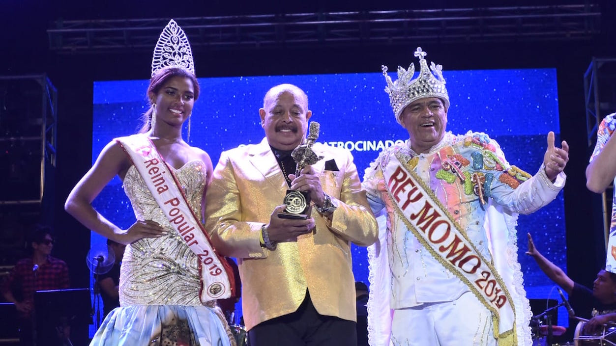 Juan Piña recibiendo la distinción con el Rey Momo Freddy Cervantes y la Reina Popular Geraldine Quiróz.