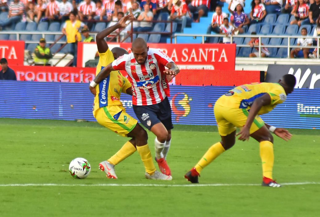 Freddy Hinestroza en jugada ofensiva entre dos rivales.