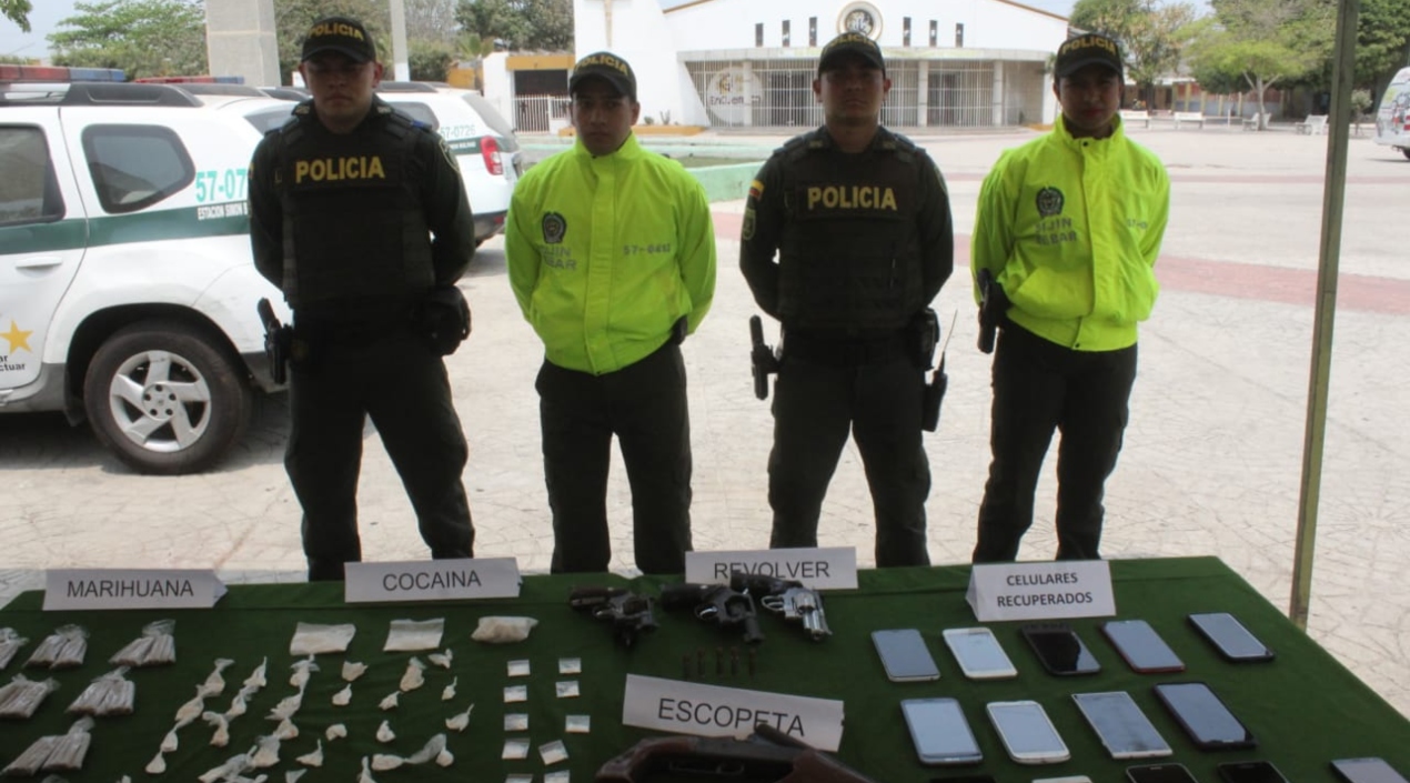 Policía presentando la droga y armas incautadas, y los celulares recuperados.