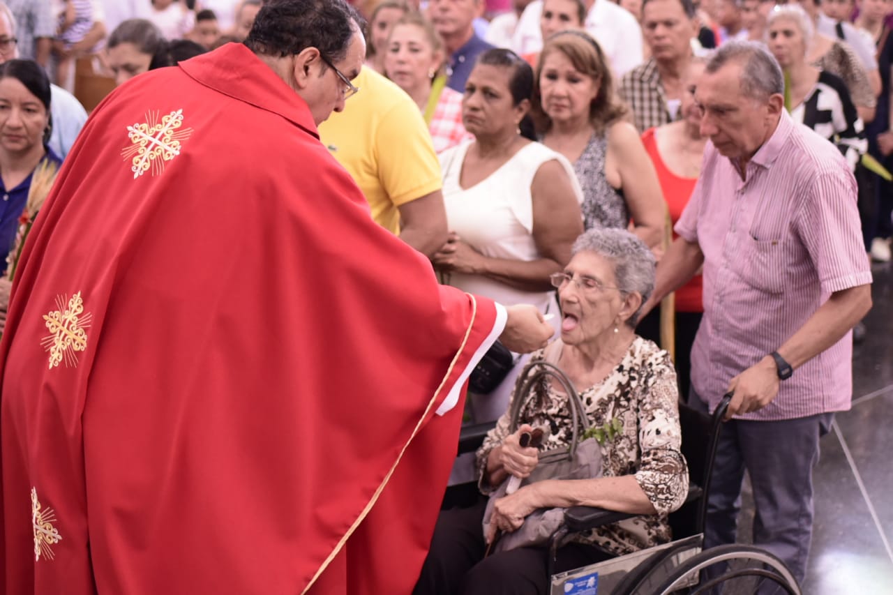 Arzobispo da la comunión a una feligrés.