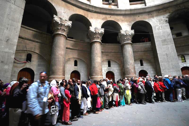 Creyentes hacen cola para entrar en la Iglesia del Santo Sepulcro, donde según los Evangelios se produjo la crucifixión, muerte y resurrección de Cristo, durante una procesión por el Viernes Santo en la Ciudad Vieja de Jerusalén.