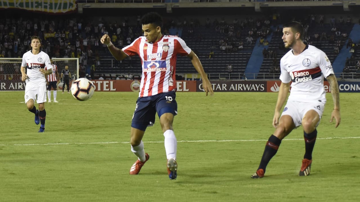 Lucho Díaz avanzando ante la marca de Marcos Senesi.