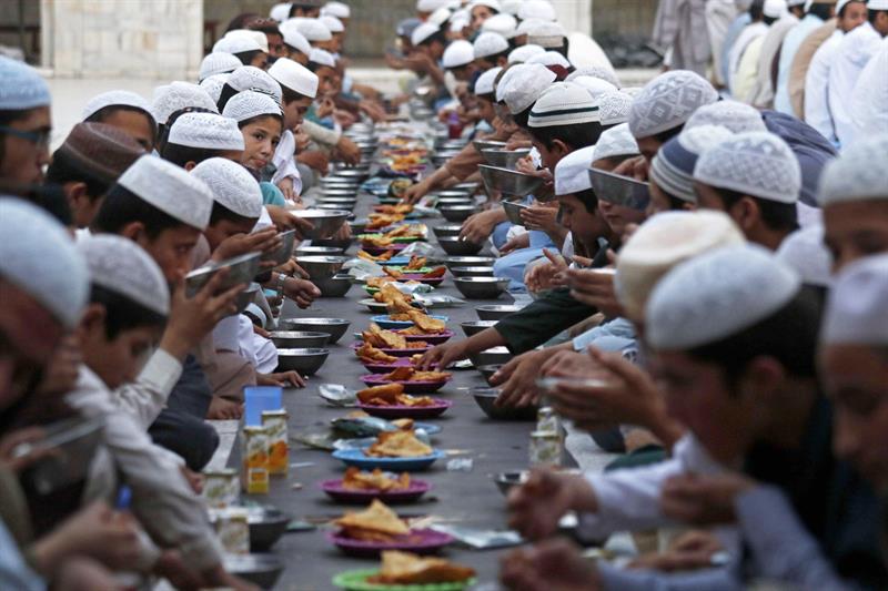 Varias personas rompen el ayuno en una mezquita durante el primer día de ramadán, este lunes en Peshawar (Pakistán).