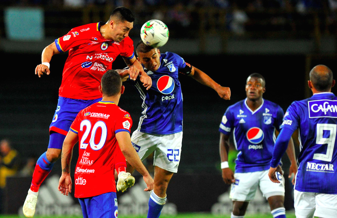 El 'embajador' Jhon Duque disputando el balón en juego aéreo.