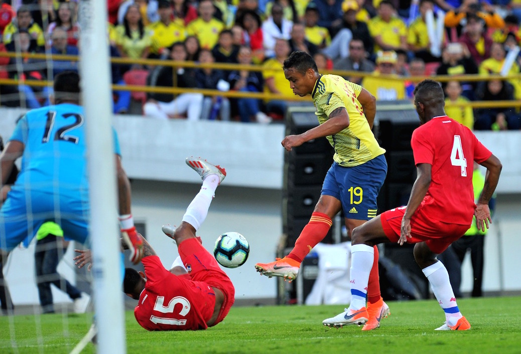 Luis Fernando Muriel rematando al arco de José Calderón frente a la marca de Eric Davis y Fidel Escobar.