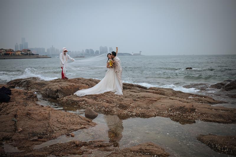 Una pareja china posa para sus fotos antes de la boda frente al Mar Amarillo, en Qingdao (China).