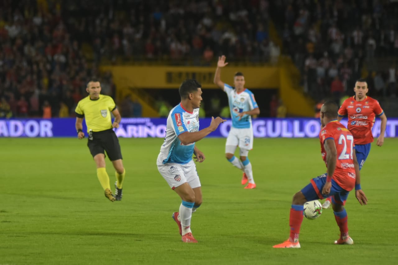 Teófilo Gutiérrez devuelve un balón con la mirada de Fabián Viáfara.