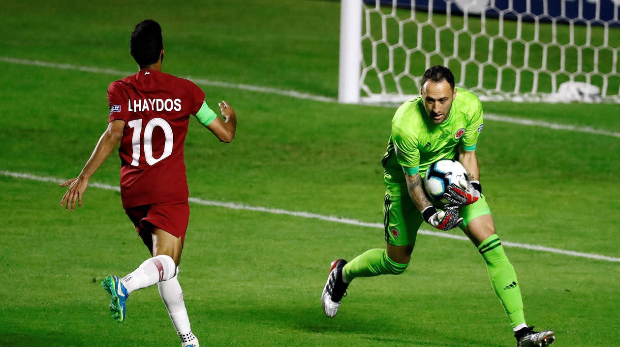 David Ospina disputa el balón con Hasan Alhaydos de Catar.
