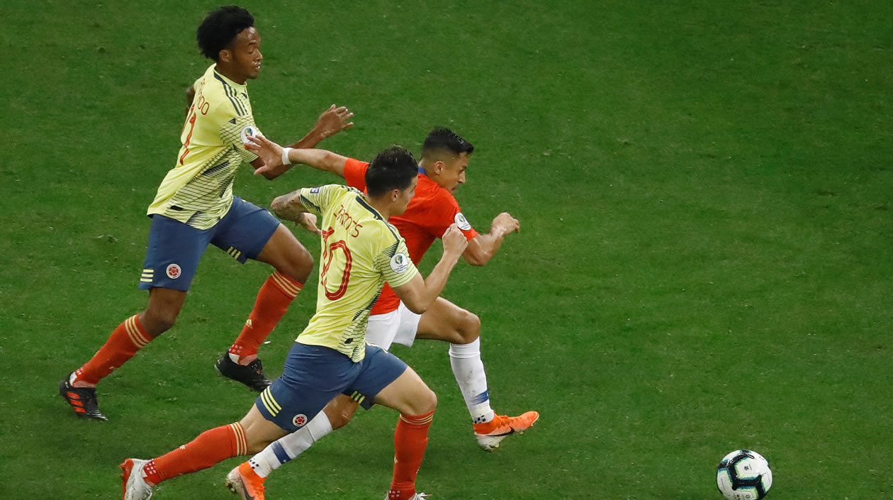 James Rodríguez, Juan Guillermo Cuadrado tras un balón contra Alexis Sánchez de Chile.