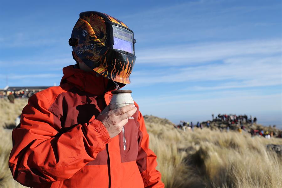 Un hombre observa el eclipse solar total con una máscara de soldar mientras toma mate, este martes en la ciudad de Merlo, San Luis (Argentina). 