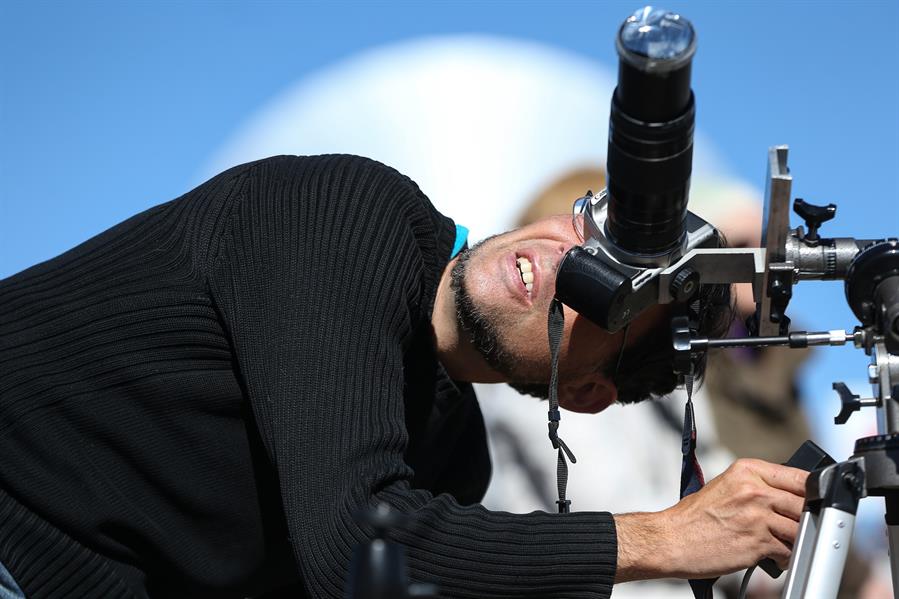 Un hombre observa el sol a través de su cámara fotográfica horas antes de que comience el eclipse solar total, este martes en el Observatorio de La Silla, situado en la región de Coquimbo (Chile).