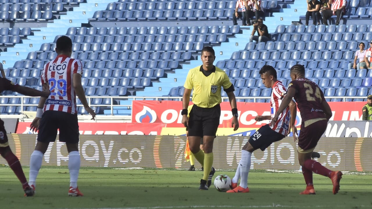 Víctor Cantillo filtrando un pase ante el asedio de Carlos Robles.
