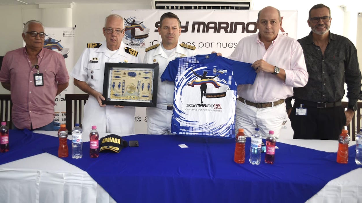 Los organizadores mostrando los cuadros que recibirán los ganadores y la camiseta conmemorativa.